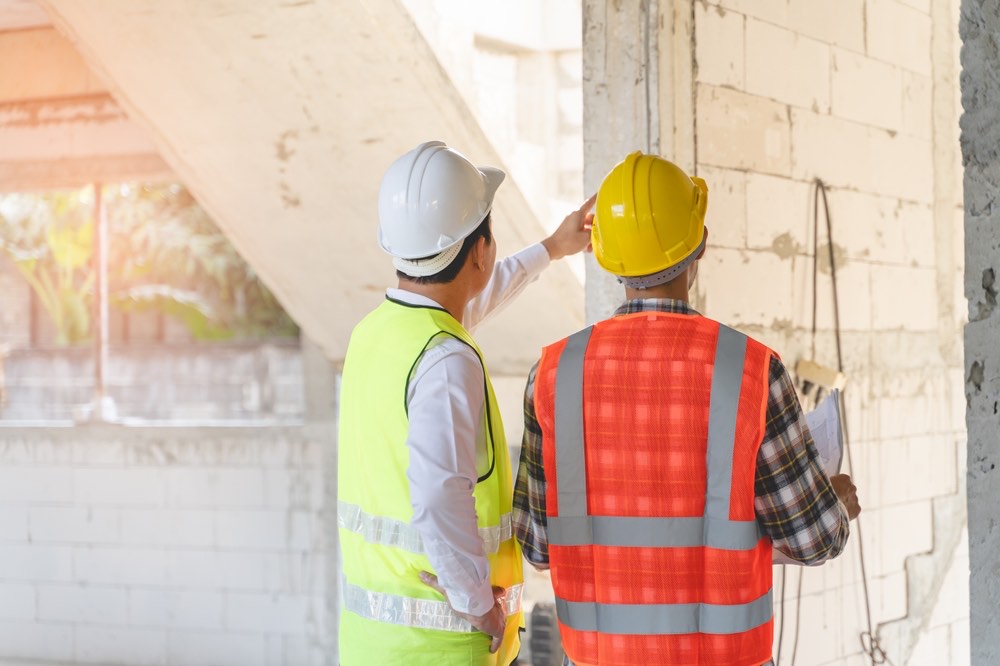 Client and contractor reviewing building renovation and fire safety plans